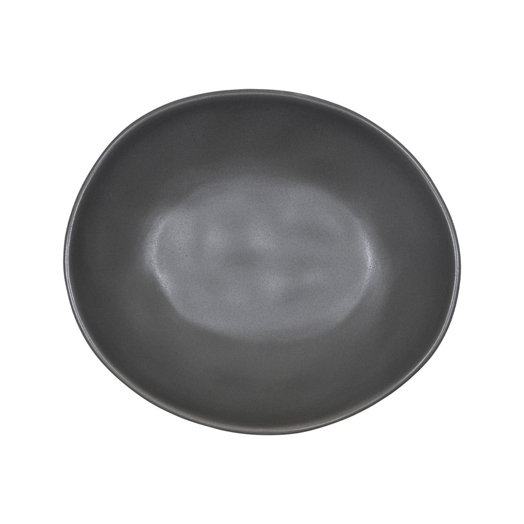 Πιάτο σε μοντέρνο στυλ από stoneware σε απόχρωση γραφίτη, τοποθετημένο σε λευκή επιφάνεια με πράσινο ύφασμα στο φόντο.