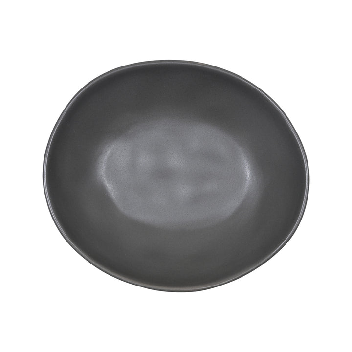 Πιάτο σε μοντέρνο στυλ από stoneware σε απόχρωση γραφίτη, τοποθετημένο σε λευκή επιφάνεια με πράσινο ύφασμα στο φόντο.