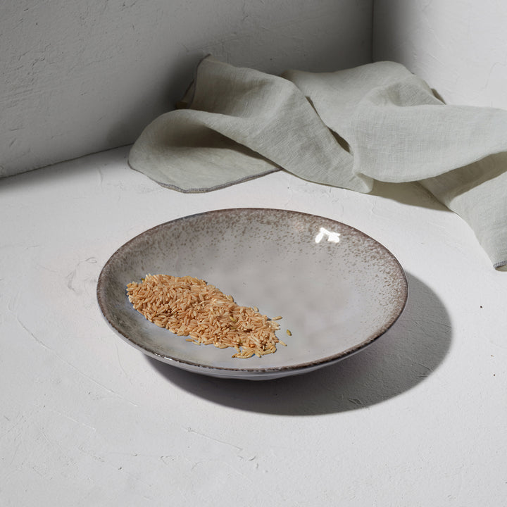 Βαθύ πιάτο Estia σε φυσικό χρώμα τοποθετημένο σε λευκή επιφάνεια με διακοσμητικό πανί.