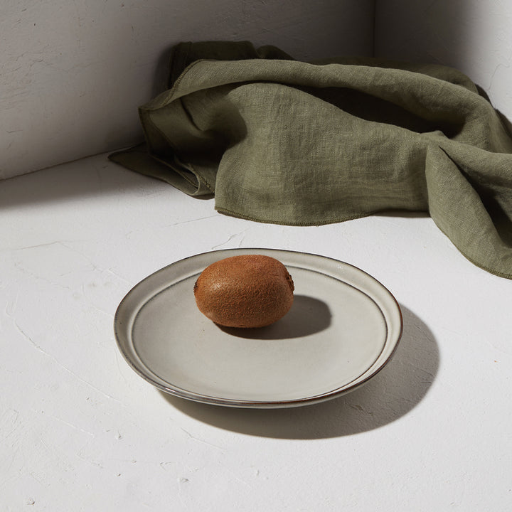 Πιάτο Deline γκρι απόχρωσης με αβοκάντο σε λευκή επιφάνεια και πράσινο ύφασμα στο φόντο.