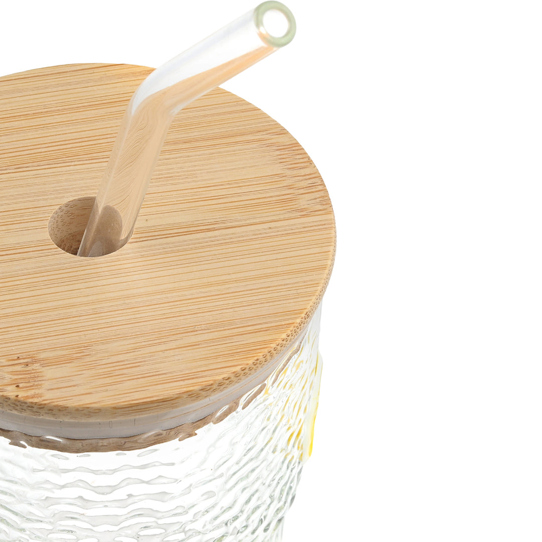 Κοντινό σε ποτήρι με ξύλινο καπάκι bamboo και γυάλινο καλαμάκι σε minimal φόντο.