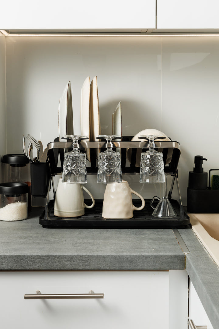 Φωτογραφία lifestyle της πιατοθήκης δίπλα στον νεροχύτη, οργανωμένη με σκεύη, αναδεικνύοντας πώς εξοικονομεί χώρο σε μια σύγχρονη κουζίνα.