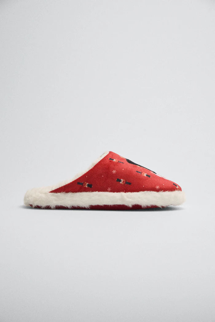 Προφίλ κόκκινης χριστουγεννιάτικης παντόφλας με σχέδιο καρυοθραύστη και απαλή λευκή γούνα στη σόλα και τα τελειώματα