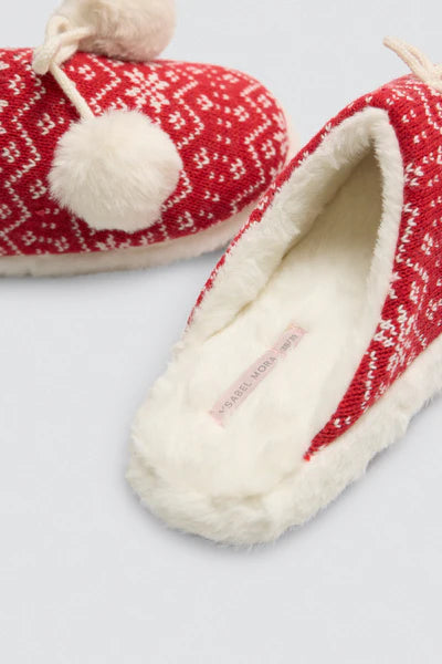 Κοντινή λήψη κόκκινης παντόφλας με λευκή γούνα, σχέδιο με λευκές νιφάδες και φουντίτσα στο πίσω μέρος