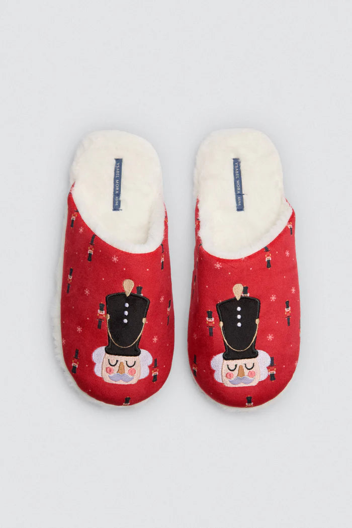 Ζευγάρι κόκκινες παντόφλες με σχέδιο καρυοθραύστη και λευκή γούνα εσωτερικά, τοποθετημένες επίπεδα σε λευκό φόντο
