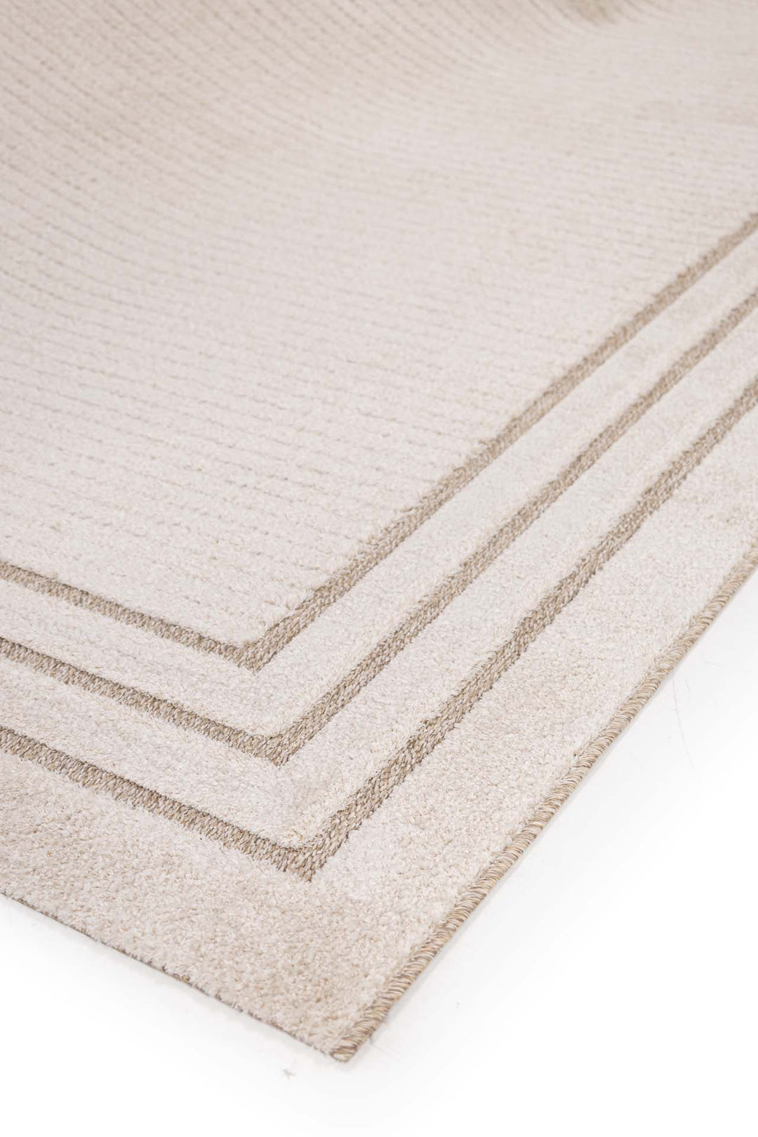 Μπεζ χαλί με τριπλό καφέ πλαίσιο, φωτογραφημένο υπό γωνία για να αναδειχθεί η υφή του.