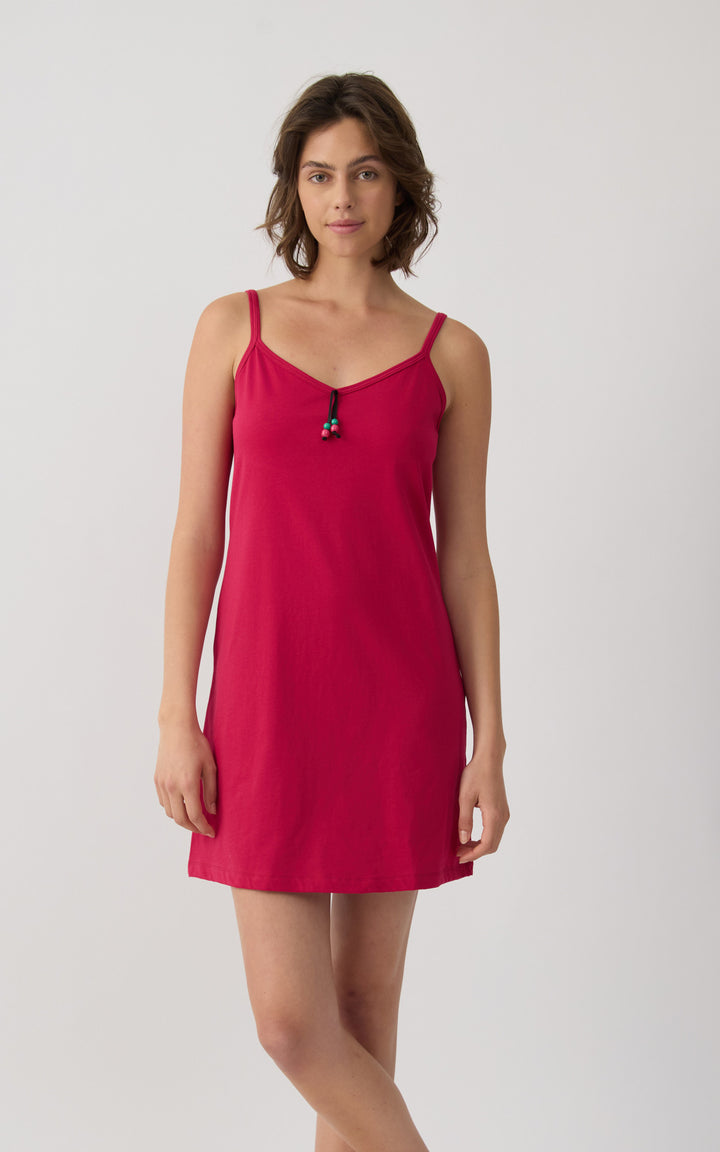 Γυναίκα φορά κόκκινο βαμβακερό αμάνικο νυχτικό Minerva με λεπτές τιράντες σε φωτεινό minimal studio φόντο.