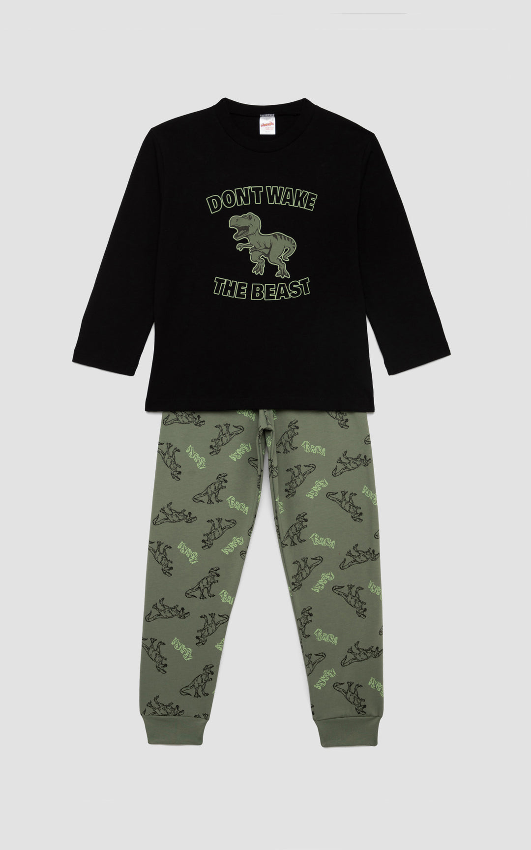 Αγορίστικη πιτζάμα με μαύρη μπλούζα και τύπωμα δεινόσαυρου "Don't wake the beast", συνδυασμένη με χακί παντελόνι γεμάτο σχέδια με δεινόσαυρους , μπροστά από απαλό γκρι φόντο.