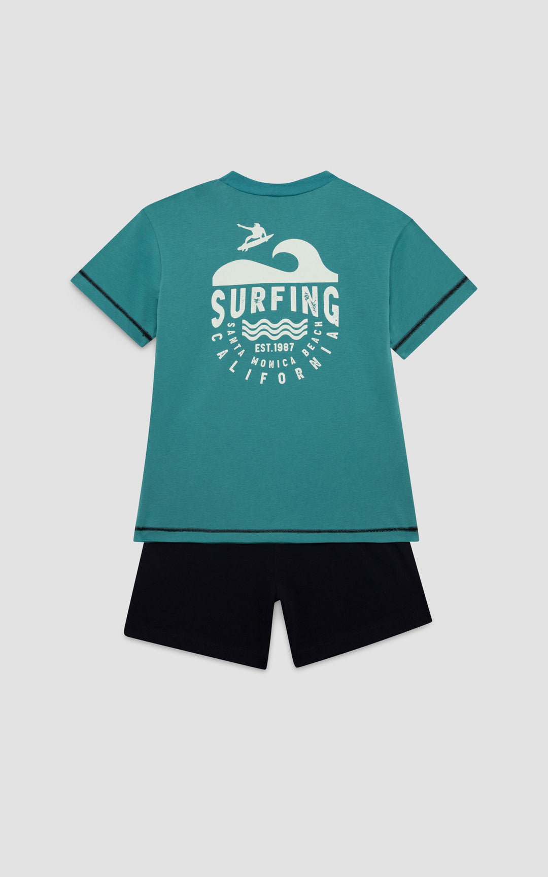 Πίσω όψη παιδικής πιτζάμας Minerva με μεγάλο surfing τύπωμα στην πλάτη και μονόχρωμη μαύρη βερμούδα.