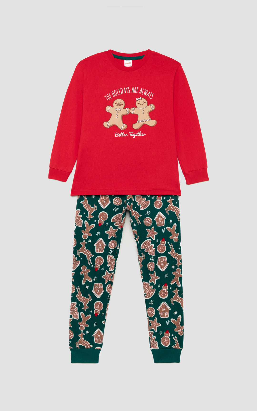 Χριστουγεννιάτικη παιδική πιζάμα σε κόκκινο χρώμα με χαρούμενα μπισκοτάκια και παιχνιδιάρικη διάθεση , μπροστά  από απαλο γκρι φόντο. 