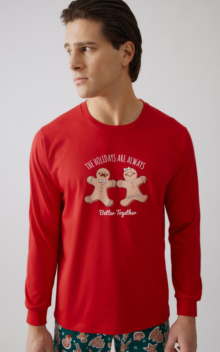 Κοντινό πλάνο μοντέλου που φοράει ανδρική πιτζμά σε κόκκινο χρώμα και παντελόνι παντελόνι γεμάτο μοτίβα από μπισκότα gingerbread.