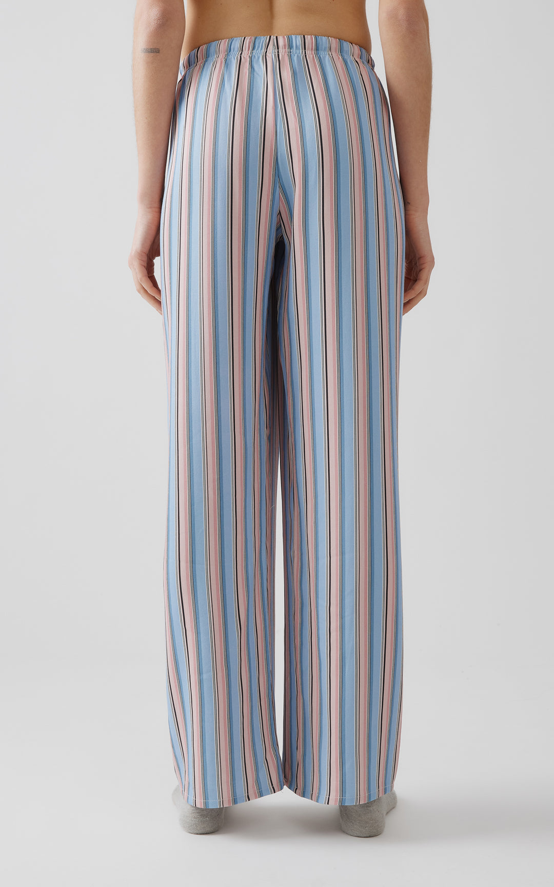 Πίσω όψη γυναικείου ριγέ παντελονιού πιτζάμας σε ροζ και γαλάζιες αποχρώσεις.