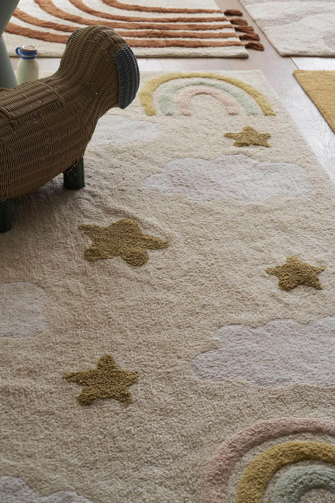 Παιδικό χαλί Little Steps της Royal Carpet σε ουδέτερη απόχρωση, τοποθετημένο σε διαμορφωμένο χώρο, με σχέδιο με ουράνιο τόξο και εμφανή υφή επιφάνειας.