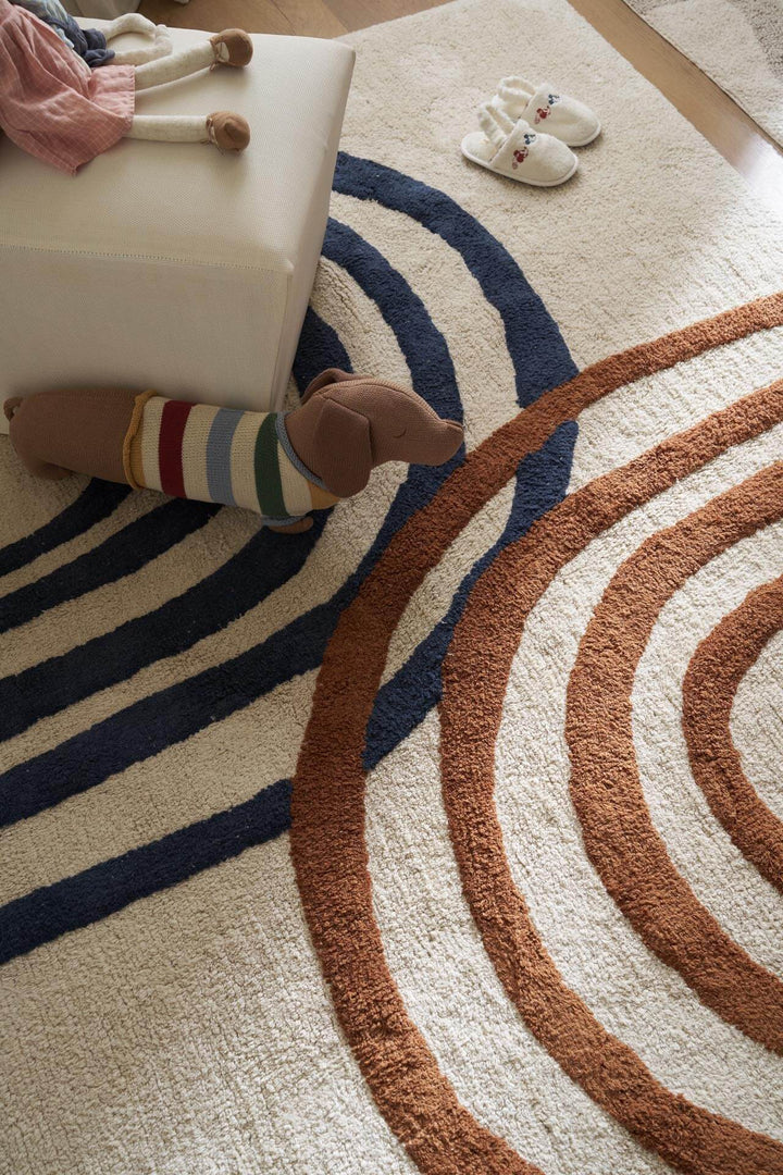 Παιδικό χαλί Little Steps της Royal Carpet σε ουδέτερη απόχρωση, τοποθετημένο σε διαμορφωμένο χώρο, με σχέδιο με ουράνιο τόξο και εμφανή υφή επιφάνειας.