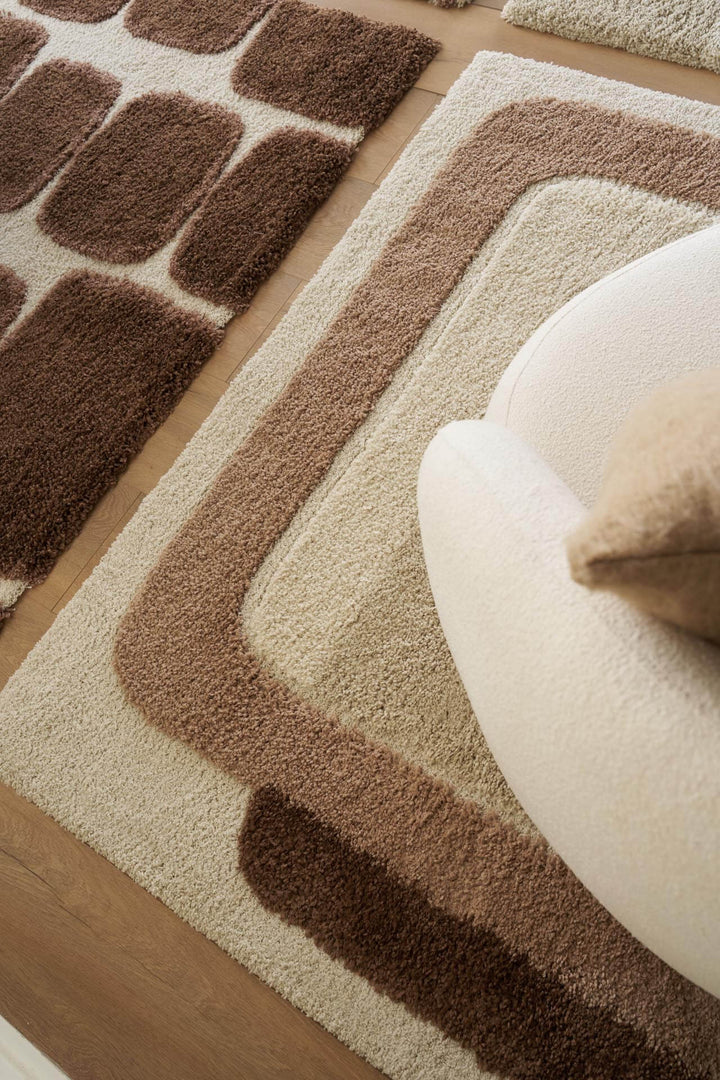 Χαλί Royal Carpet της Royal Carpet σε καφέ, τοποθετημένο σε διαμορφωμένο χώρο, με προσεγμένο σχέδιο της σειράς και εμφανή υφή επιφάνειας.