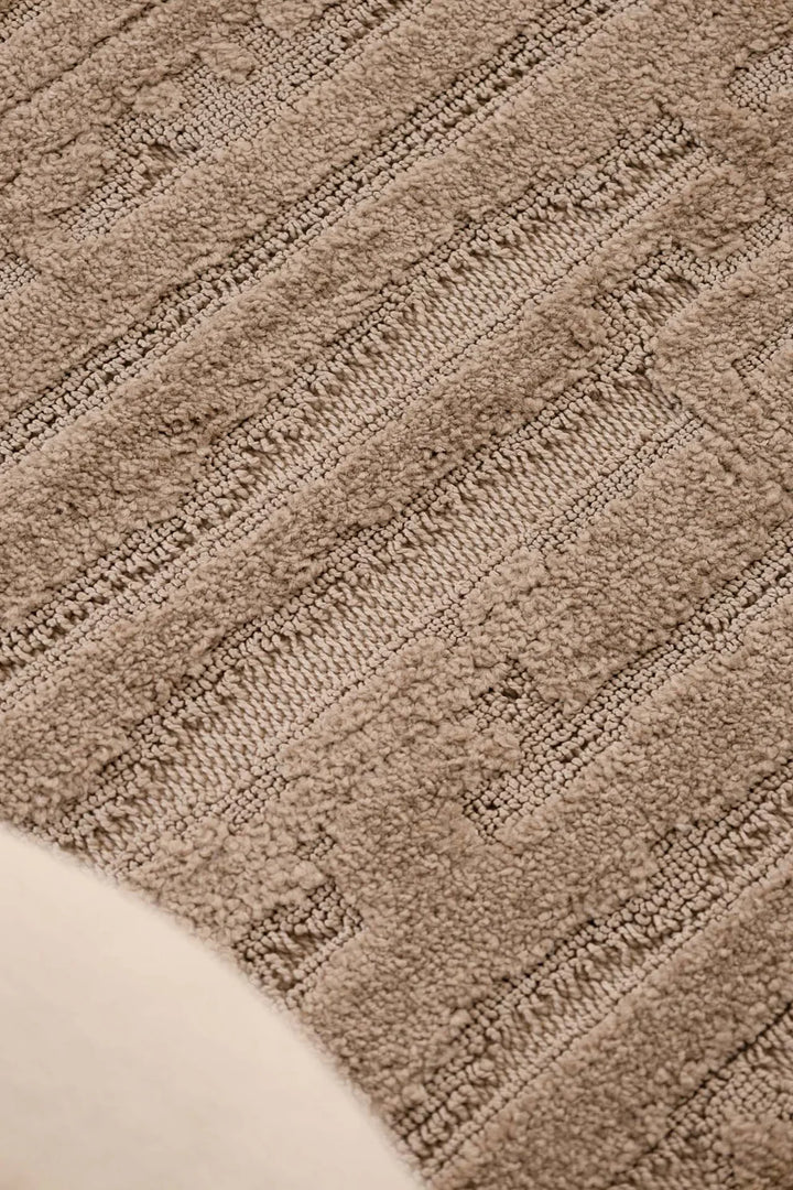 Κοντινή λήψη του μοντέρνου χαλιού Chiara Royal Carpet σε καφέ απόχρωση, με έντονη ανάγλυφη υφή και γεωμετρικά γραμμικά μοτίβα που αναδεικνύουν τη λεπτομέρεια της ύφανσης.