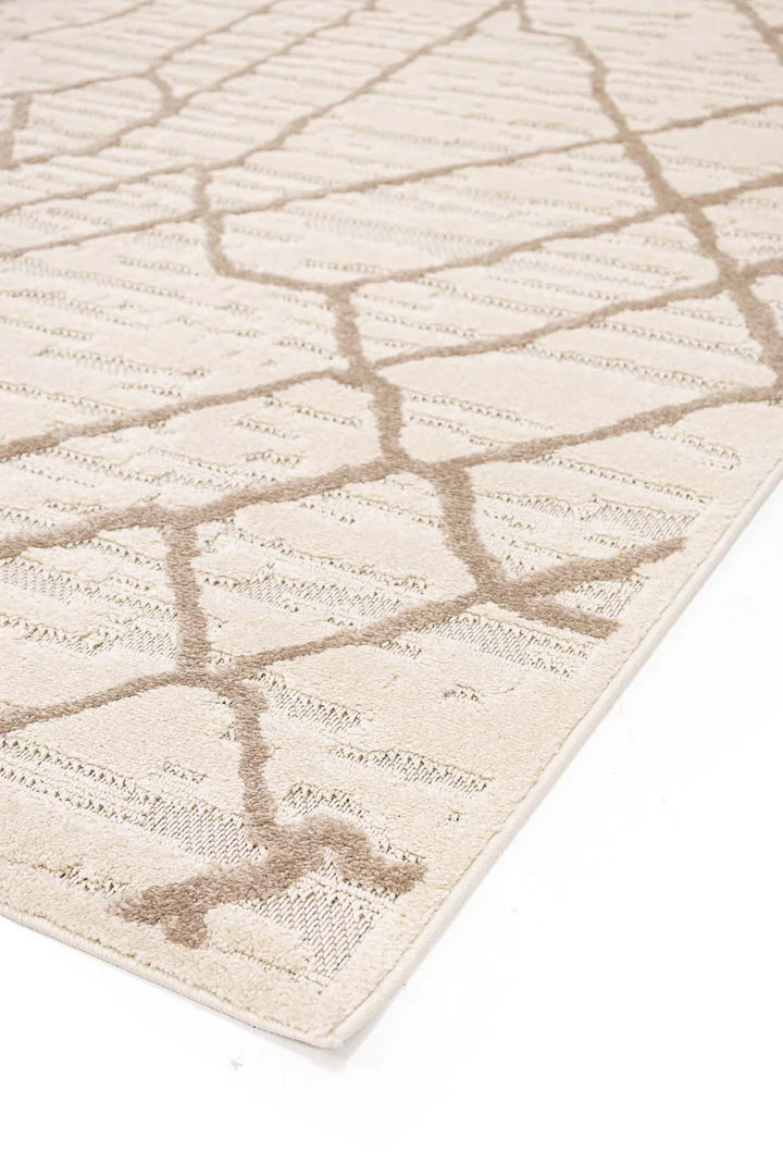Γωνιακή λήψη του μοντέρνου χαλιού Chiara Royal Carpet σε εκρού και μπεζ αποχρώσεις με ανάγλυφο αφηρημένο μοτίβο, φωτογραφημένο σε λευκό φόντο για ανάδειξη του σχεδίου και της υφής.