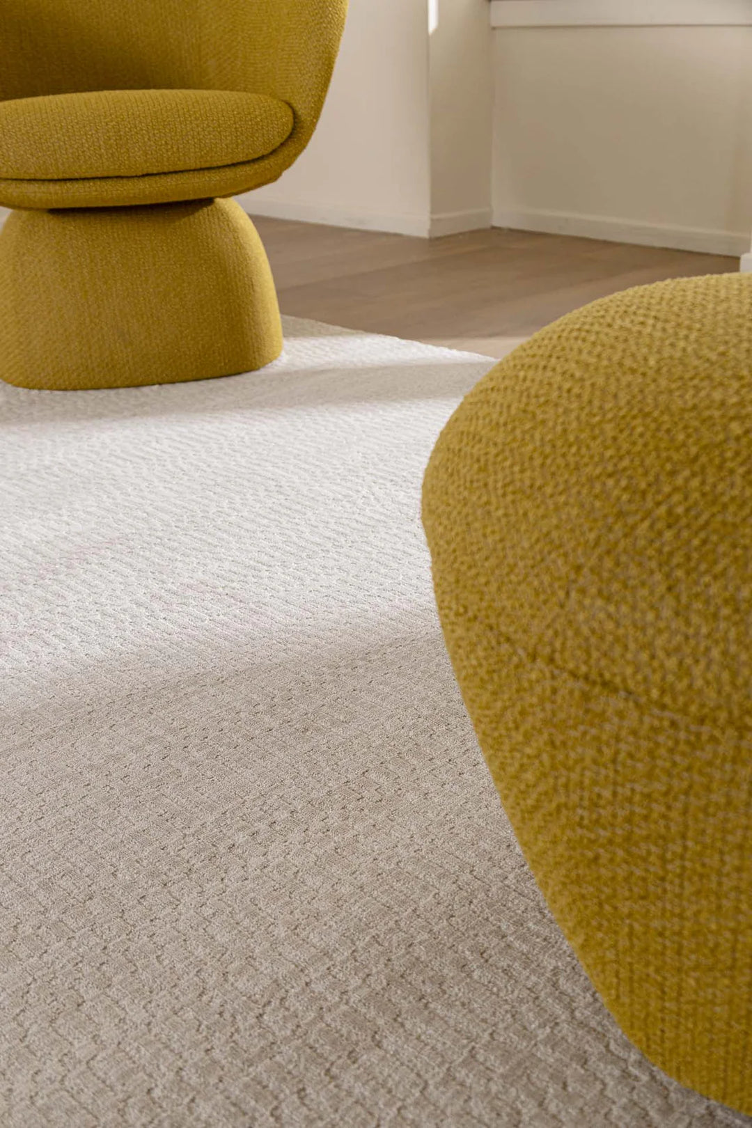 Minimal χώρος με μονόχρωμο λευκό χαλί Royal Carpet και μοντέρνα ώχρα πολυθρόνα σε φυσικό φωτισμό.
