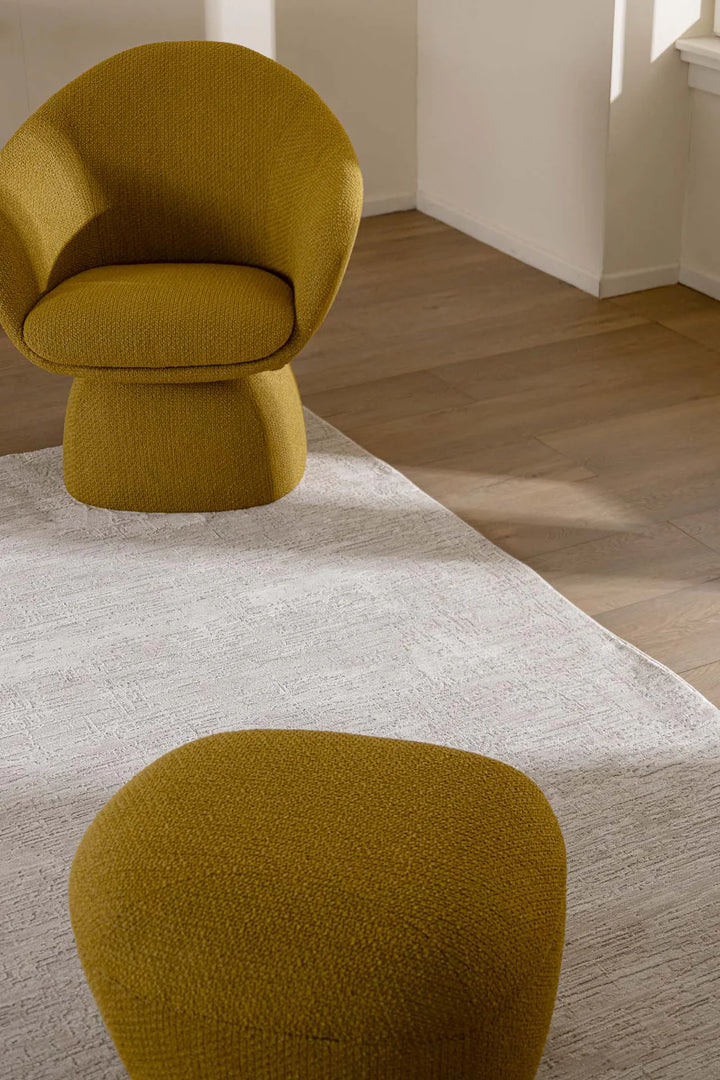 Λευκό χαλί Prime Royal Carpet σε μοντέρνο σαλόνι με ώχρα πολυθρόνα και ξύλινο πάτωμα.