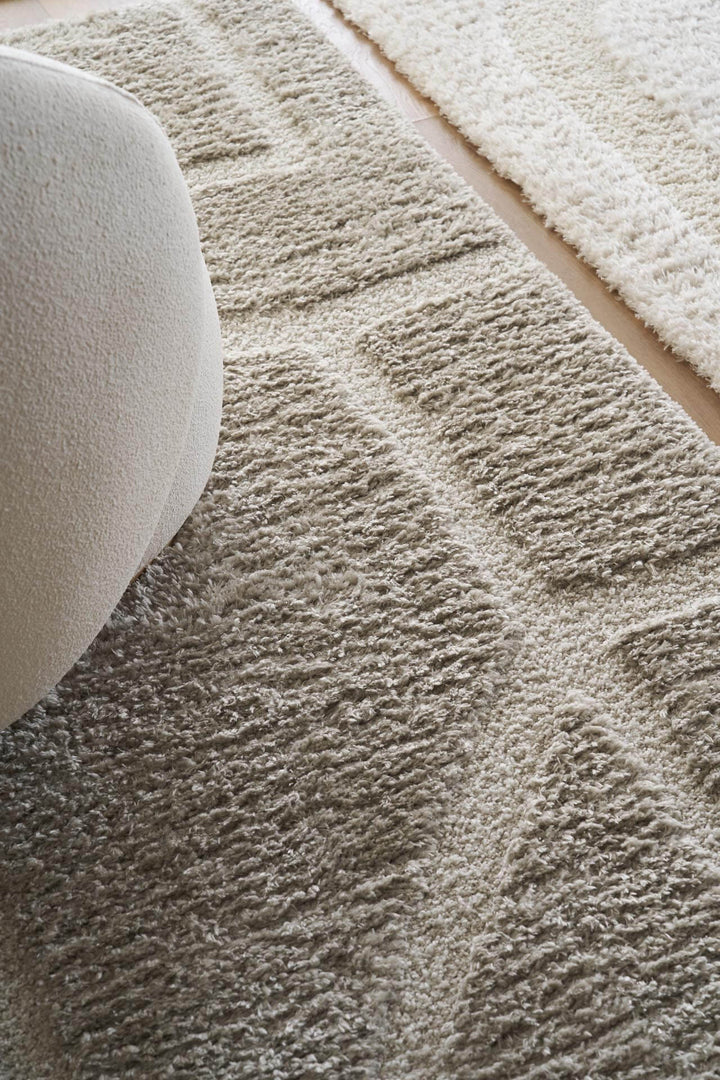 Χαλί Relief της Royal Carpet σε εκρού και γκρι, τοποθετημένο σε διαμορφωμένο χώρο, με ανάγλυφη επιφάνεια και εμφανή υφή επιφάνειας.