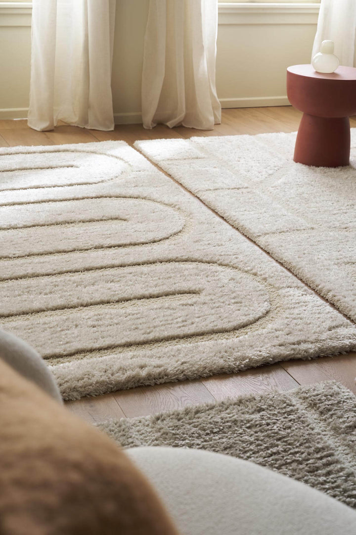 Χαλί Relief της Royal Carpet σε εκρού, τοποθετημένο σε διαμορφωμένο χώρο, με ανάγλυφη επιφάνεια και εμφανή υφή επιφάνειας.