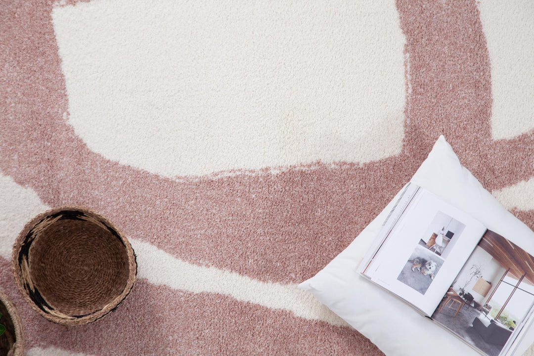 Λεπτομέρεια του χαλιού Lilly Royal Carpet σε λευκό και απαλό ροζ χρώμα, με shaggy υφή και μοντέρνο αφηρημένο σχέδιο.